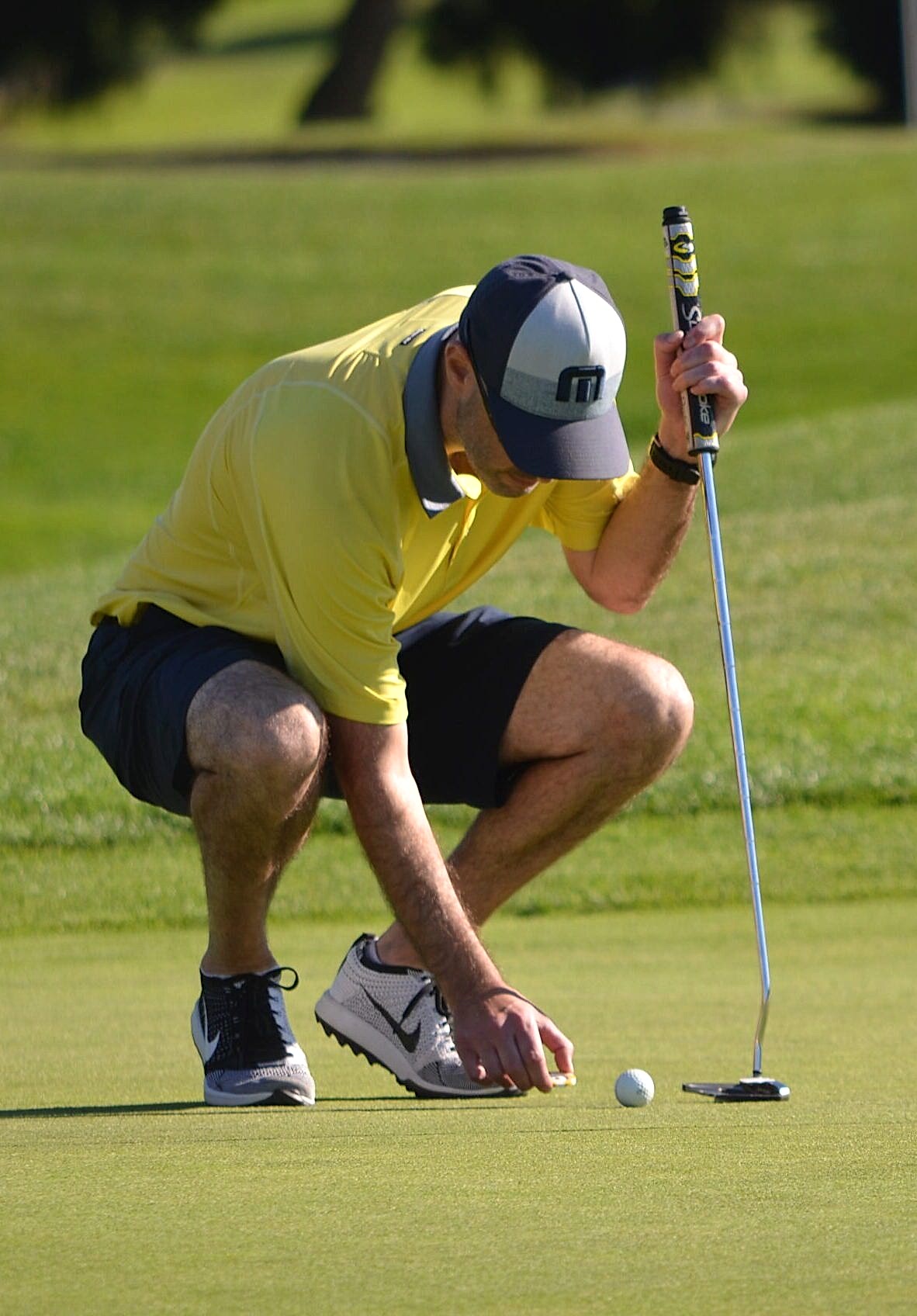 Golfer kneeling on the course